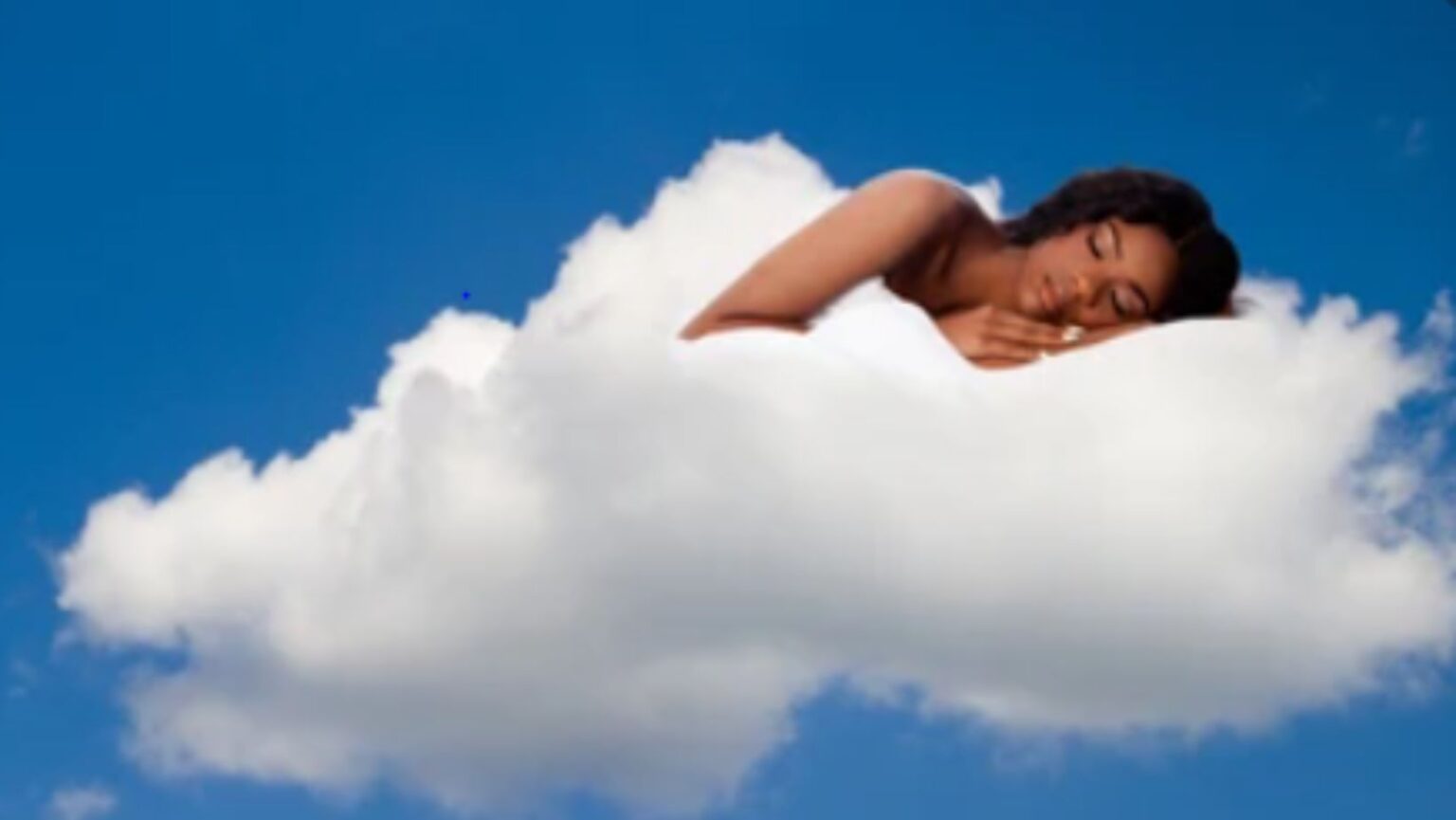 A black woman sleeping easily in a cloud